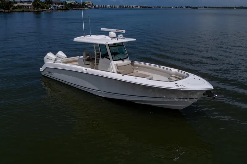 Ducky's Dinghy Yacht Photos Pics 2020 Boston Whaler 330 Outrage boat on calm water, showcasing sleek design and luxury features.