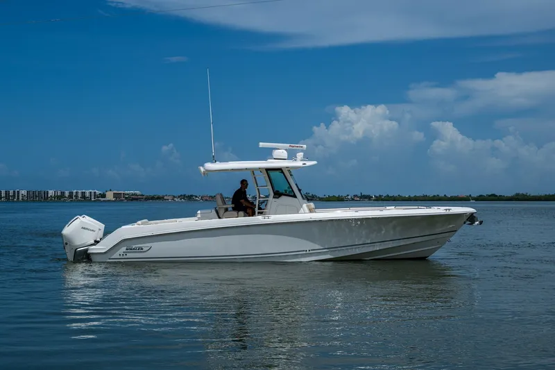 Ducky's Dinghy Yacht Photos Pics 2020 Boston Whaler 330 Outrage boat cruising on calm waters under a clear blue sky.