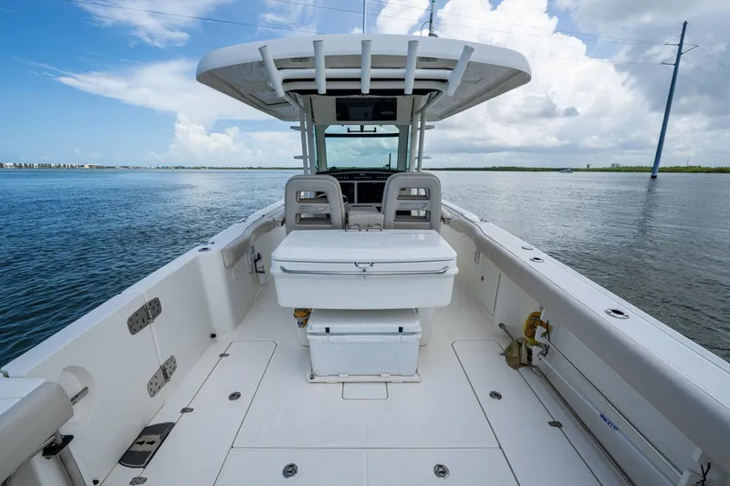 Ducky's Dinghy Yacht Photos Pics 2020 Boston Whaler 330 Outrage boat on calm water, showcasing spacious deck and seating.