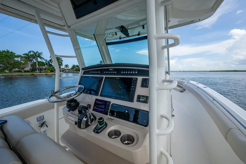 Ducky's Dinghy Yacht Photos Pics 2020 Boston Whaler 330 Outrage helm with advanced navigation system on a calm waterway.
