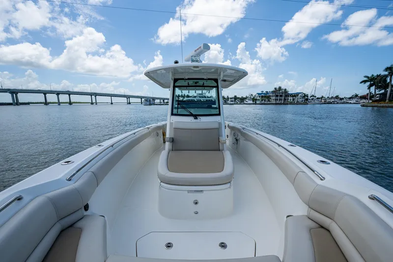 Ducky's Dinghy Yacht Photos Pics 2020 Boston Whaler 330 Outrage boat on calm water with bridge and marina view.