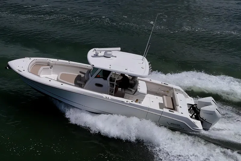 Ducky's Dinghy Yacht Photos Pics 2020 Boston Whaler 330 Outrage boat cruising on water, showcasing sleek design and powerful engines.