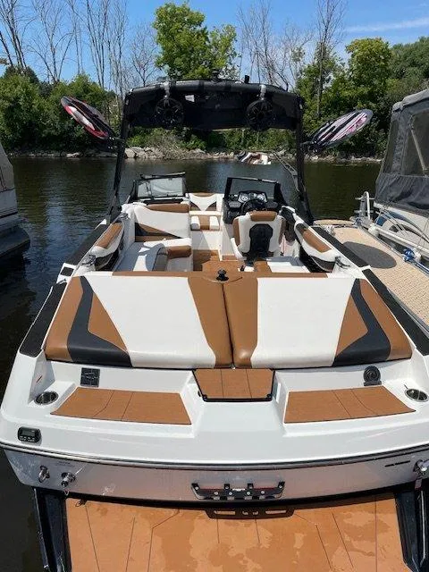2021 Axis T23 boat with sleek design, brown and white seating, docked on a sunny day.