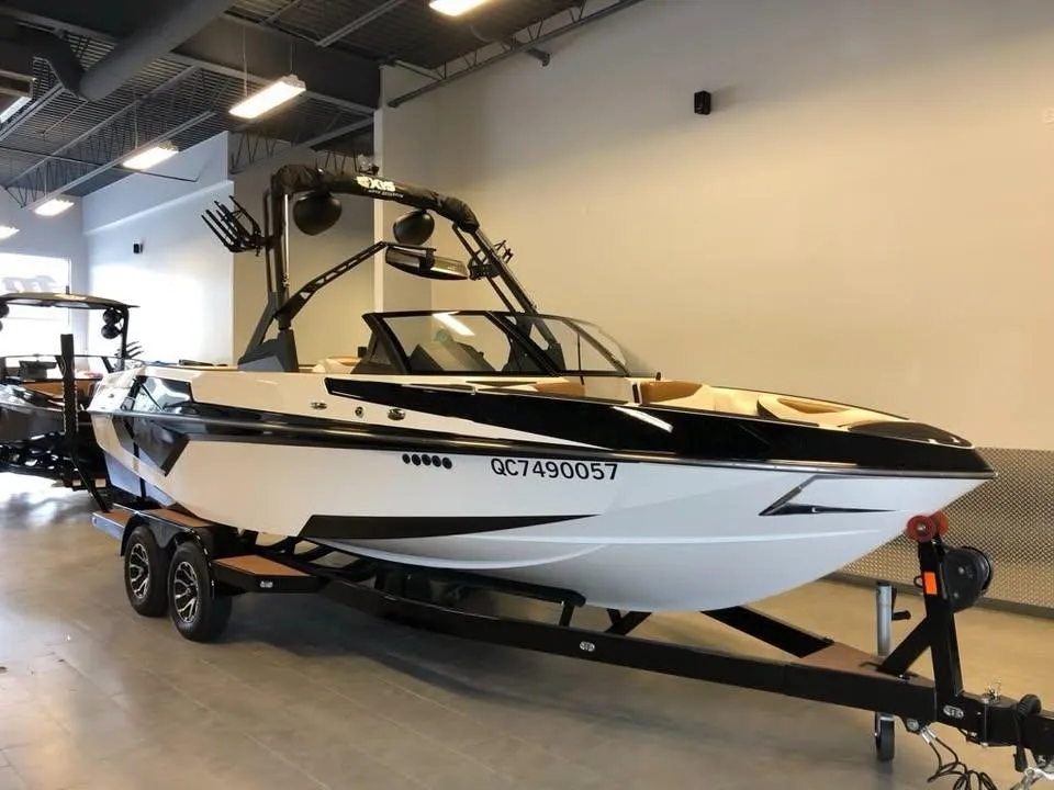 2021 Axis T23 boat on trailer in showroom, sleek design, black and white color scheme.