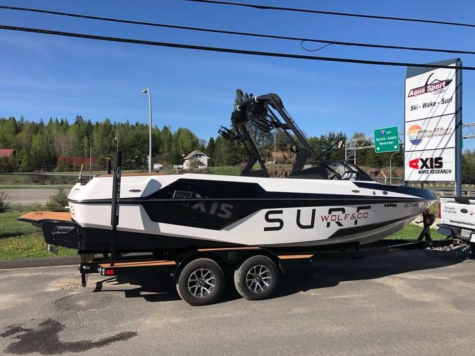 2021 Axis T23 boat on trailer, parked outdoors near Aqua Sport sign.