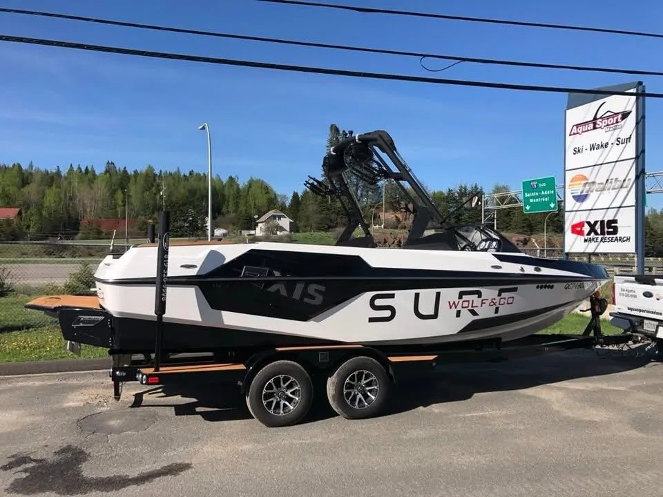 2021 Axis T23 boat on trailer, parked outdoors near Aqua Sport sign.