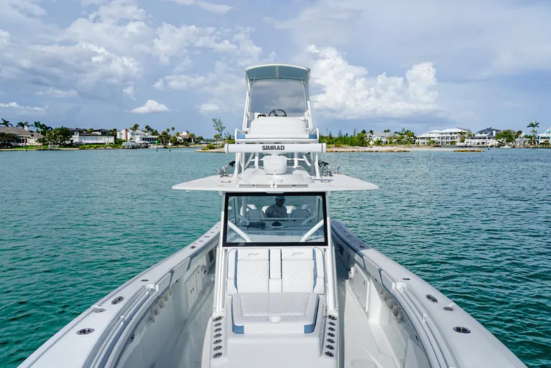  Yacht Photos Pics 2023 Yellowfin 42 boat on calm water with coastal background.