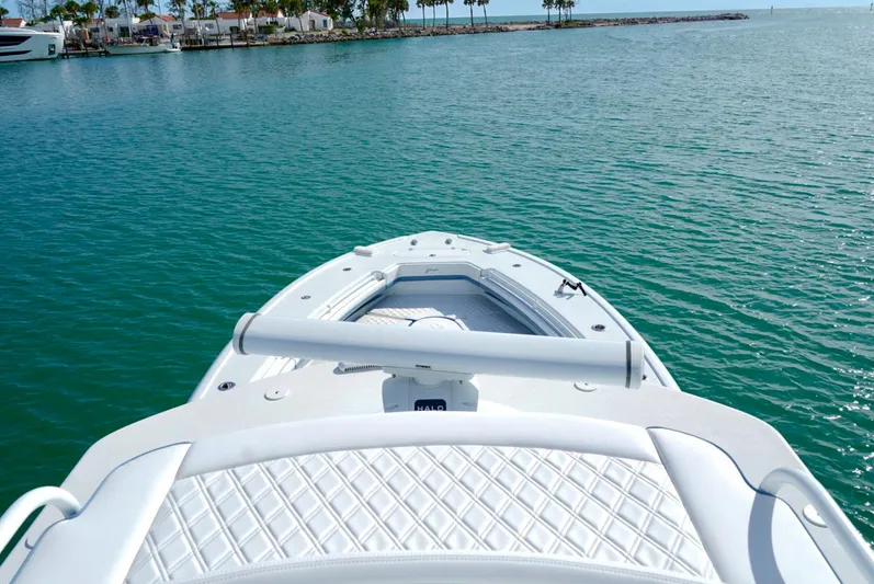 Yacht Photos Pics 2023 Yellowfin 42 boat on calm turquoise water near a marina.