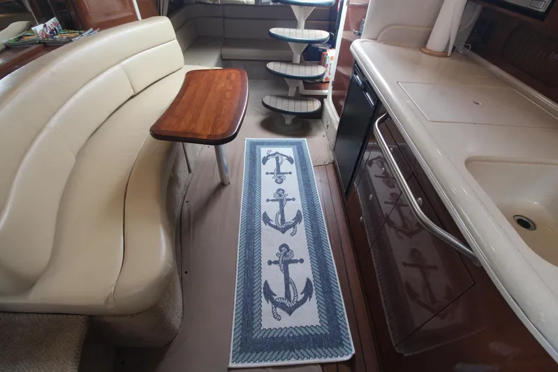  Yacht Photos Pics Interior of 2008 Sea Ray 340 Sundancer with beige seating and anchor-themed rug.