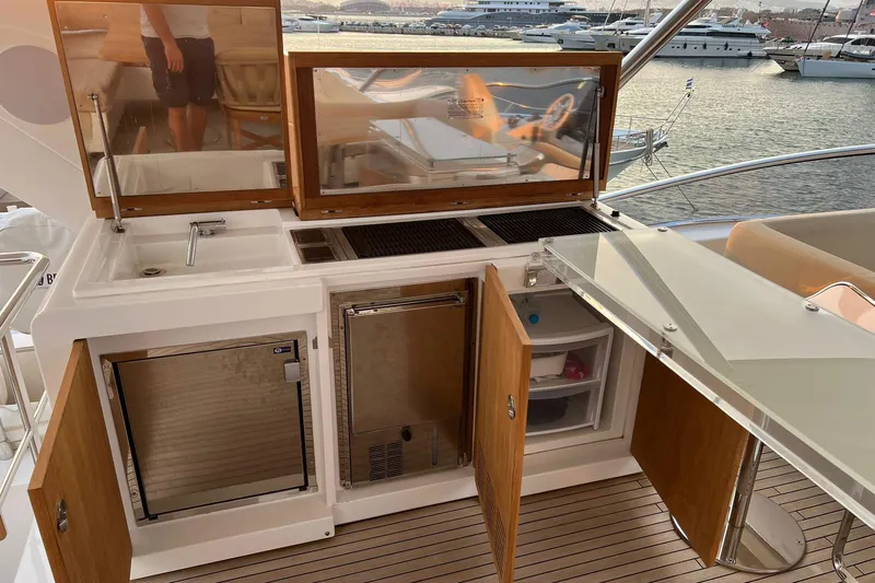  Yacht Photos Pics Outdoor kitchen on 2015 Azimut 80 yacht with sink, grill, and storage, overlooking marina.