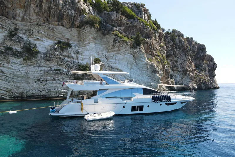  Yacht Photos Pics Luxury 2015 Azimut 80 yacht anchored near rocky cliffside in clear blue waters.