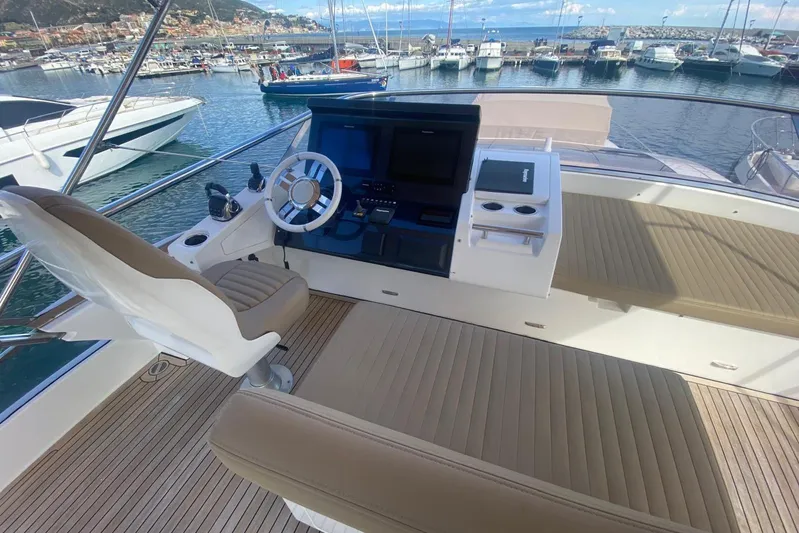 Yacht Photos Pics Luxurious 2016 Azimut 77S yacht helm with modern controls and comfortable seating in a marina.