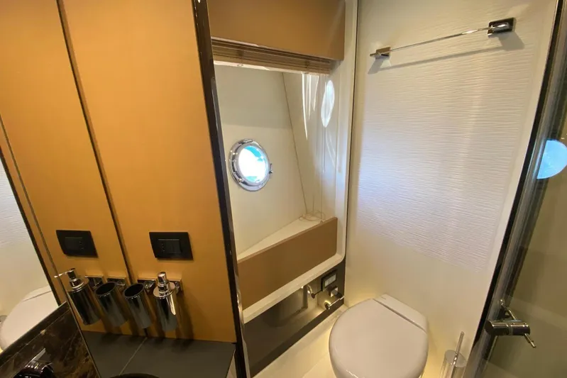  Yacht Photos Pics Luxurious bathroom in 2016 Azimut 77S yacht with modern fixtures and porthole window.