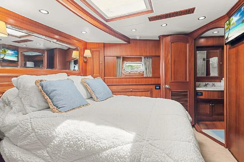 Seas To See Yacht Photos Pics Luxurious bedroom in 2006 Paragon Cockpit Motoryacht with wood paneling and cozy bedding.