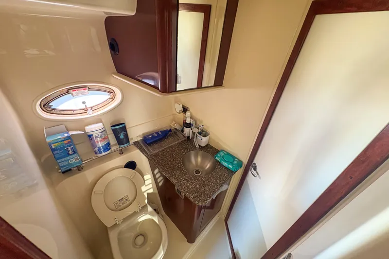 Luna Yacht Photos Pics Compact bathroom in 2008 Sea Ray 380 Sundancer yacht with sink, toilet, and porthole window.