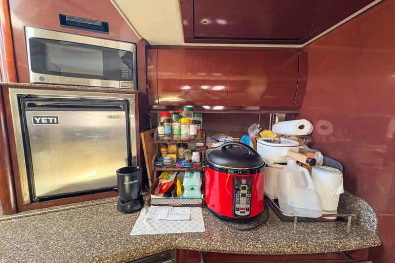 Luna Yacht Photos Pics Galley kitchen in 2008 Sea Ray 380 Sundancer with microwave, mini fridge, and cooking essentials.
