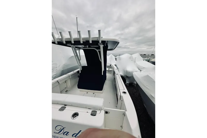 Robalo 272 Yacht Photos Pics 2022 Robalo R272 Center Console boat with covered seating, docked under cloudy skies.