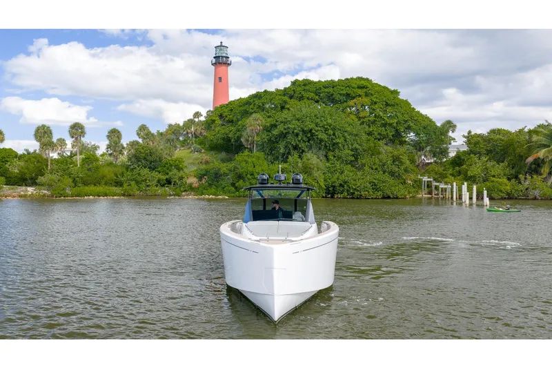  Yacht Photos Pics 2024 Pardo Yachts 43 cruising near a lush island with a lighthouse.