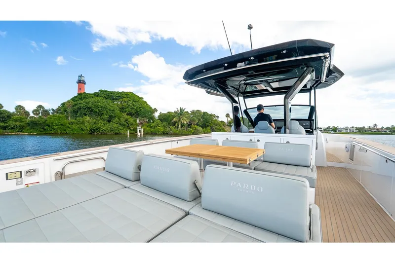  Yacht Photos Pics 2024 Pardo Yachts 43 cruising near a scenic lighthouse and lush greenery.