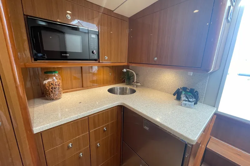 Lady Faye Yacht Photos Pics Luxurious 2018 Viking 37 Billfish yacht kitchen with microwave, sink, and wooden cabinetry.