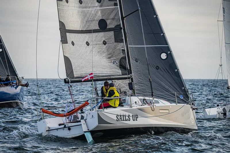 Sails Up Yacht Photos Pics Sailing on a 2022 Beneteau First 27 yacht with black sails on open water.