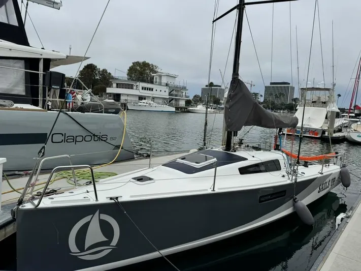 Sails Up Yacht Photos Pics 2022 Beneteau First 27 sailboat docked in a marina, featuring sleek design and modern amenities.