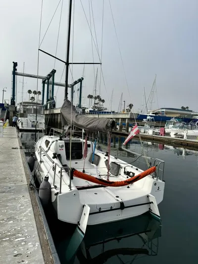 Sails Up Yacht Photos Pics 2022 Beneteau First 27 sailboat docked in a marina, featuring sleek design and modern rigging.