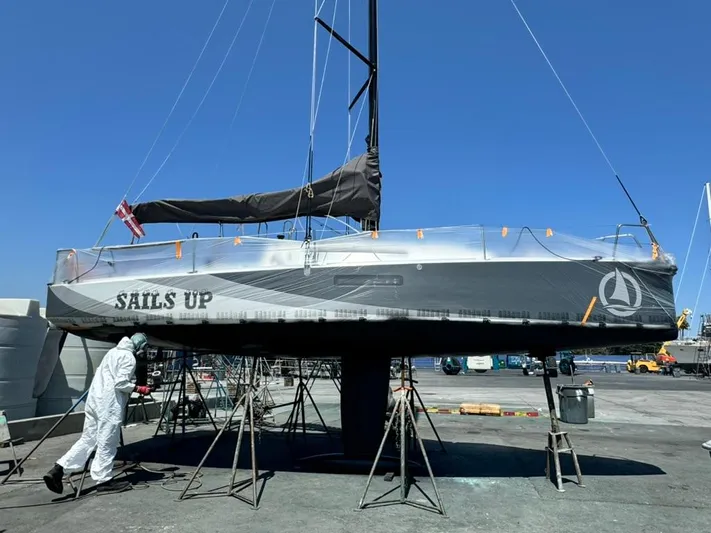Sails Up Yacht Photos Pics 2022 Beneteau First 27 sailboat on stands, undergoing maintenance at a marina.