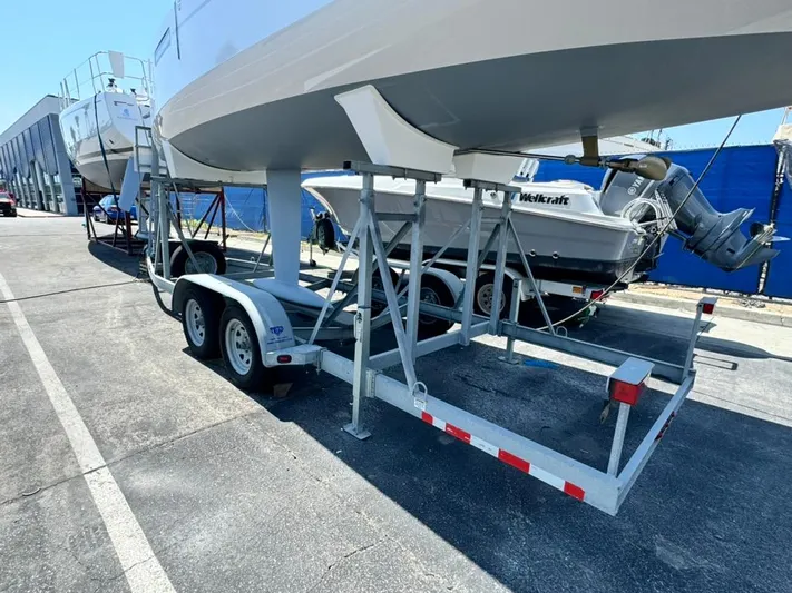 Sails Up Yacht Photos Pics 2022 Beneteau First 27 sailboat on a trailer, parked outdoors.