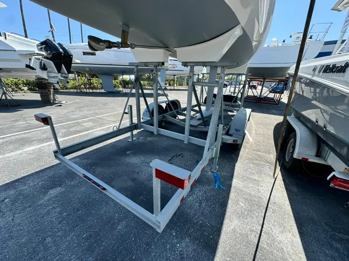 Sails Up Yacht Photos Pics 2022 Beneteau First 27 sailboat on trailer in marina storage area.