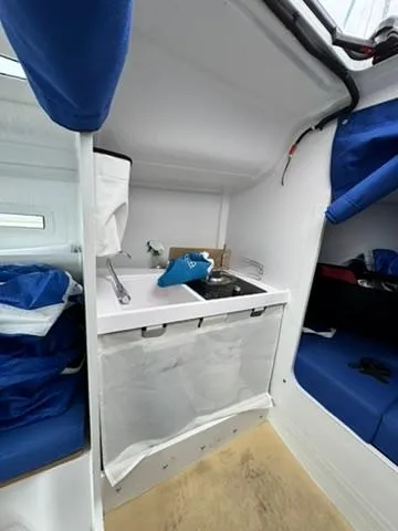 Sails Up Yacht Photos Pics Interior of 2022 Beneteau First 27 sailboat with compact kitchen area.
