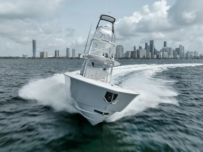  Yacht Photos Pics 2024 Contender 44 ST boat speeding on water with city skyline in background.