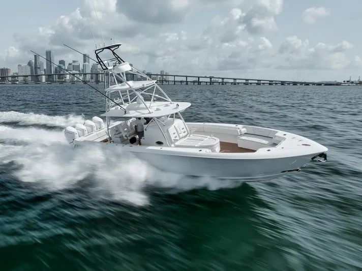  Yacht Photos Pics 2024 Contender 44 ST boat speeding on water near city skyline.