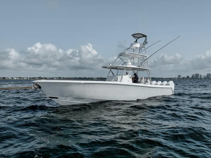  Yacht Photos Pics 2024 Contender 44 ST boat cruising on open water under a cloudy sky.
