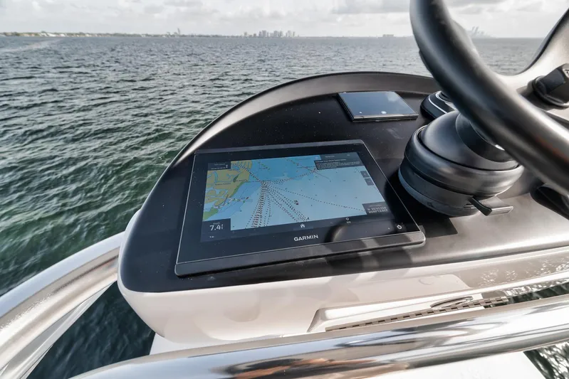  Yacht Photos Pics 2024 Contender 44 ST boat dashboard with Garmin navigation system on open water.