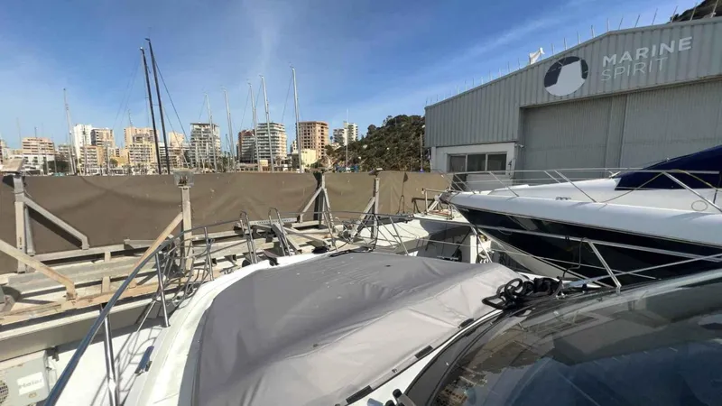  Yacht Photos Pics 2024 Galeon 410 HTC yacht docked near Marine Spirit building, city skyline in background.