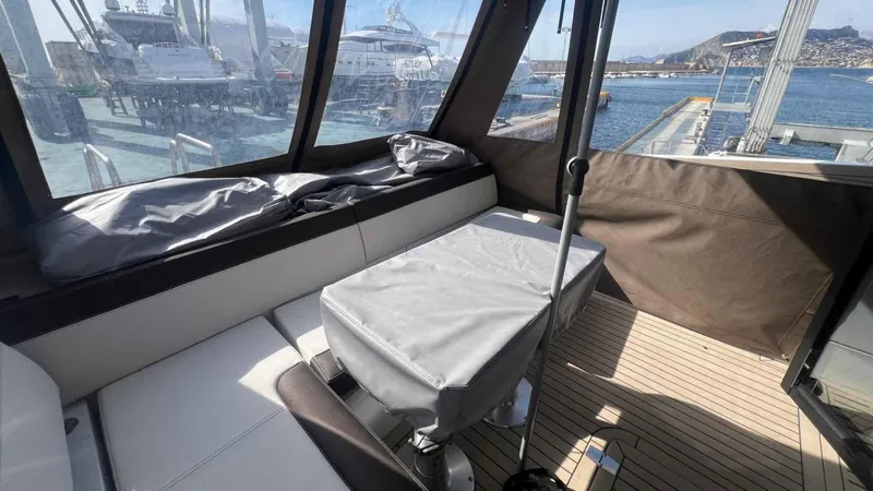  Yacht Photos Pics 2024 Galeon 410 HTC yacht interior with seating and covered table, docked at marina.