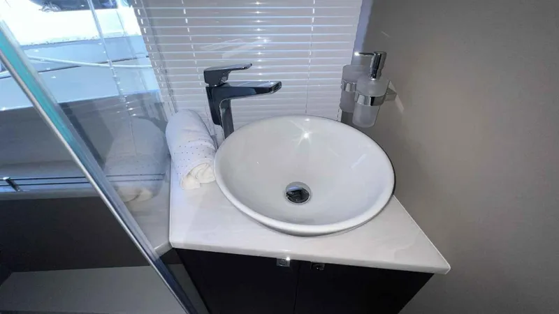  Yacht Photos Pics Modern bathroom sink on Galeon 410 HTC yacht, 2024 model, with sleek faucet and rolled towel.