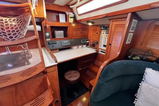Unicorn Yacht Photos Pics 1988 Hylas Custom 44 yacht interior with wooden cabinetry and navigation station.