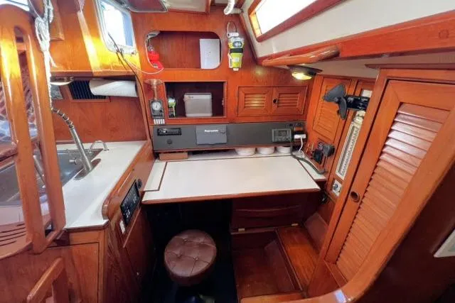 Unicorn Yacht Photos Pics 1988 Hylas Custom 44 yacht interior with wooden cabinetry and navigation station.