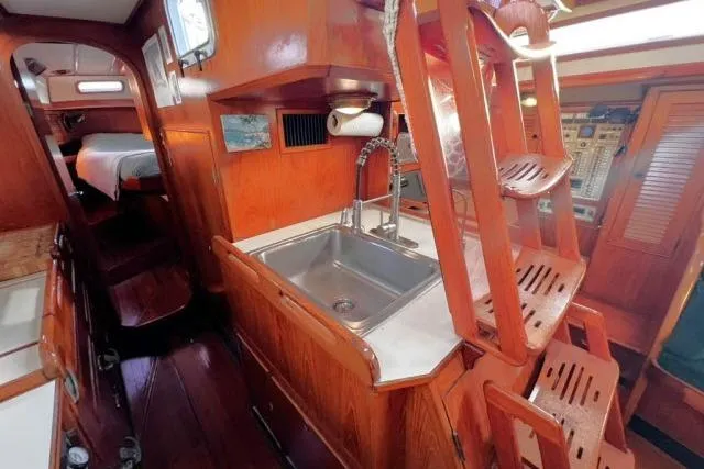 Unicorn Yacht Photos Pics 1988 Hylas Custom 44 yacht interior with wooden cabinetry and compact kitchen sink.