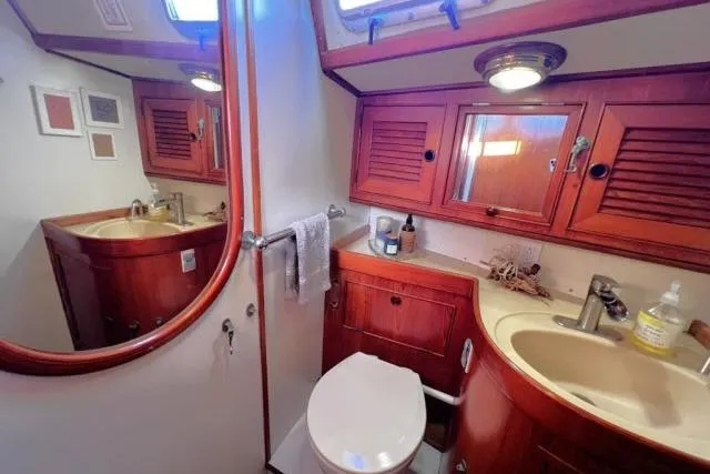 Unicorn Yacht Photos Pics Luxurious bathroom in 1988 Hylas Custom 44 yacht with wooden cabinetry and modern fixtures.