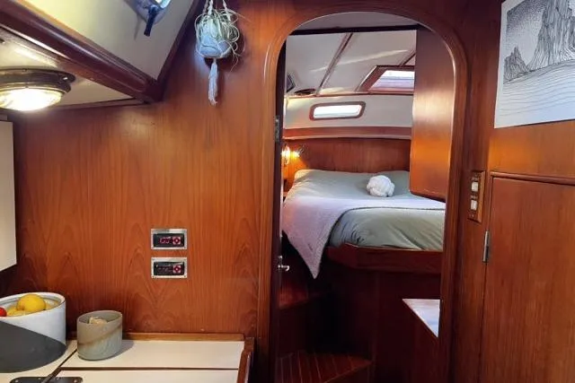 Unicorn Yacht Photos Pics Cozy interior of 1988 Hylas Custom 44 sailboat with wood paneling and comfortable sleeping area.