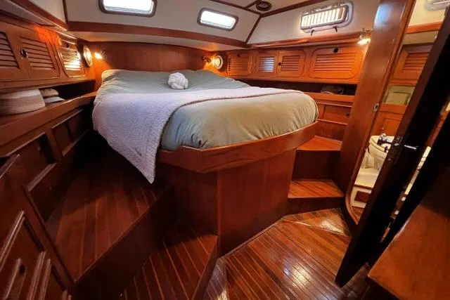Unicorn Yacht Photos Pics Luxurious 1988 Hylas Custom 44 yacht cabin with wooden interior and cozy bed.