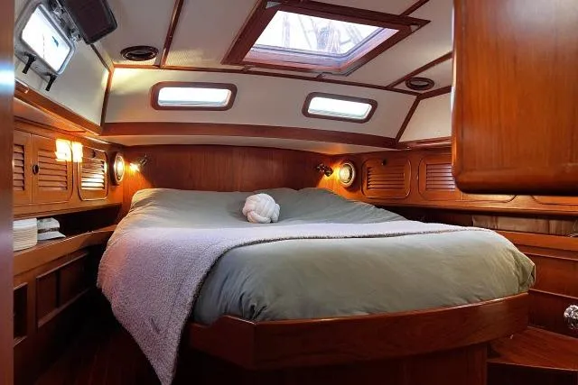 Unicorn Yacht Photos Pics Cozy cabin interior of 1988 Hylas Custom 44 sailboat with wood paneling and skylight.
