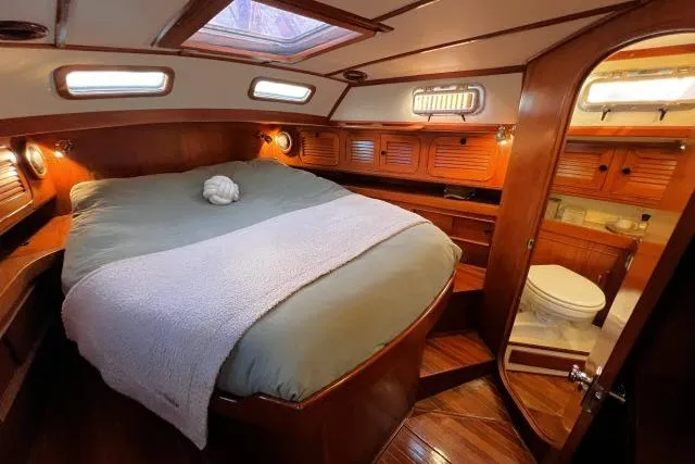 Unicorn Yacht Photos Pics Luxurious cabin interior of 1988 Hylas Custom 44 yacht with cozy bed and ensuite bathroom.