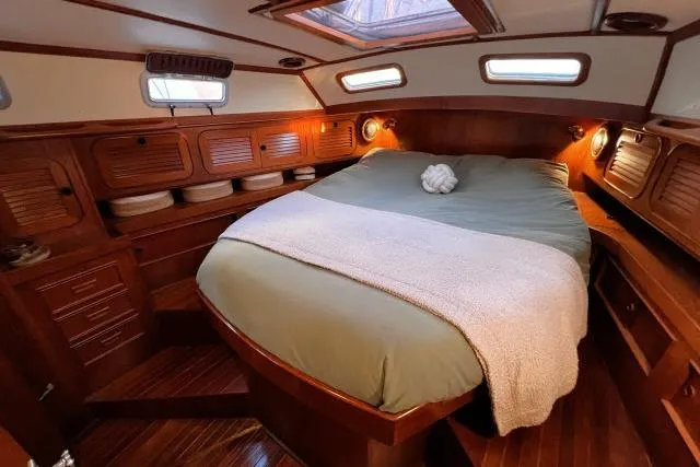 Unicorn Yacht Photos Pics Cozy cabin interior of 1988 Hylas Custom 44 yacht with wooden finishes and comfortable bedding.