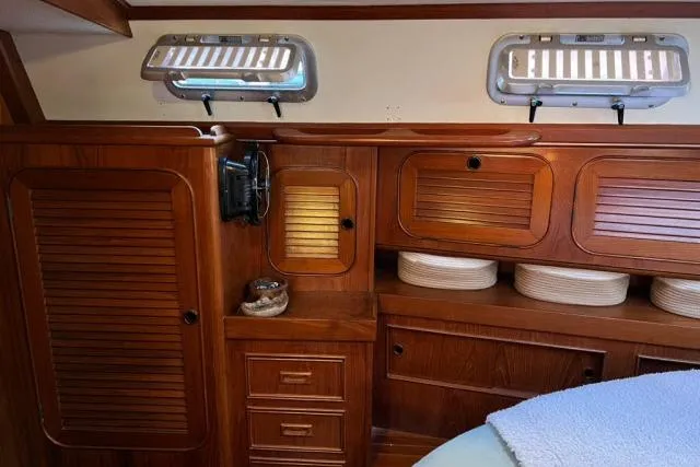 Unicorn Yacht Photos Pics Interior of 1988 Hylas Custom 44 yacht with wooden cabinetry and portholes.