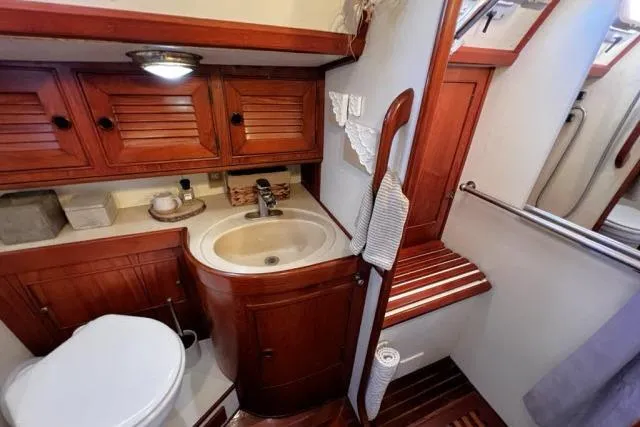 Unicorn Yacht Photos Pics 1988 Hylas Custom 44 yacht bathroom with wooden cabinetry and compact sink.