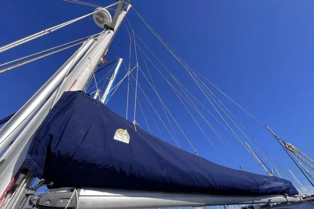 Unicorn Yacht Photos Pics Sailboat mast and boom of 1988 Hylas Custom 44 against clear blue sky.